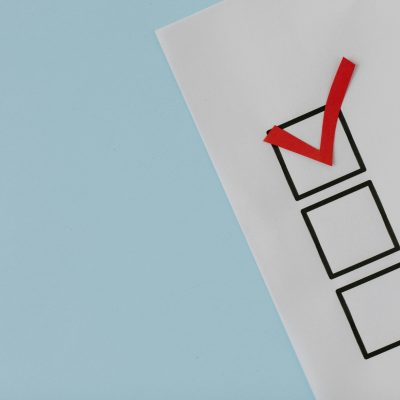 A simple white paper checklist with one red checkmark, ideal for concepts like completion or approval.
